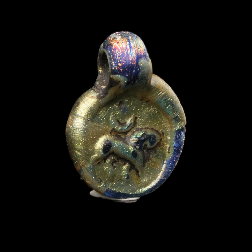 Late Roman glass amulet pendant with Lion, Moon and Sun/Star