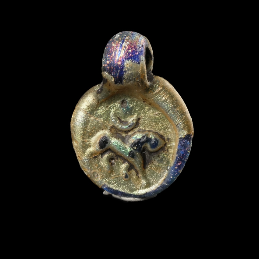 Late Roman glass amulet pendant with Lion, Moon and Sun/Star